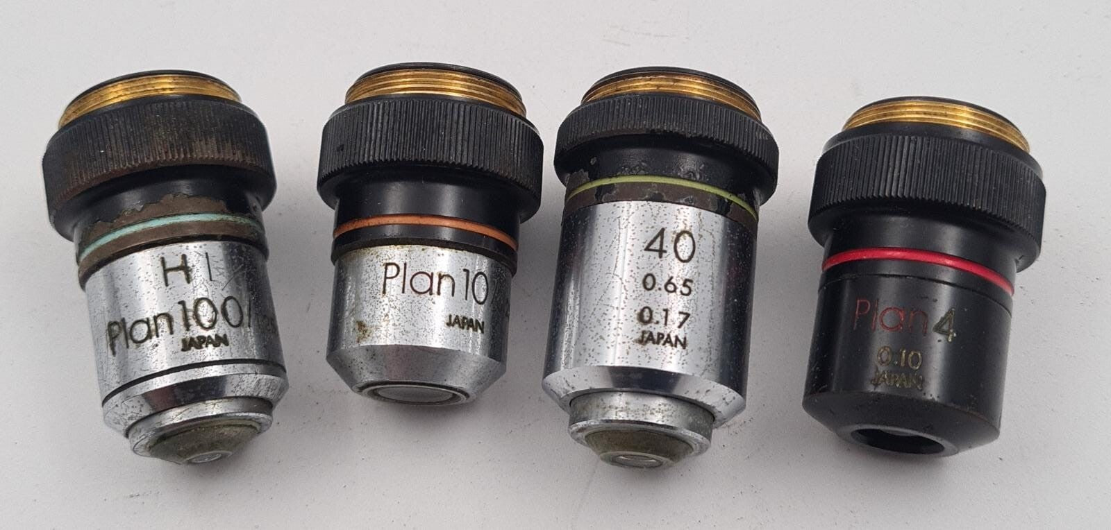 Olympus HI PLAN microscope objective lens set showing four lenses
