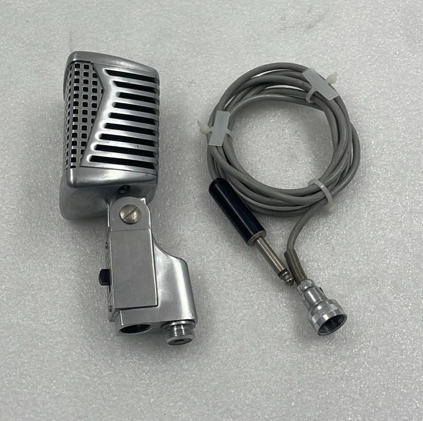 Vintage-style microphone with cable on a gray background